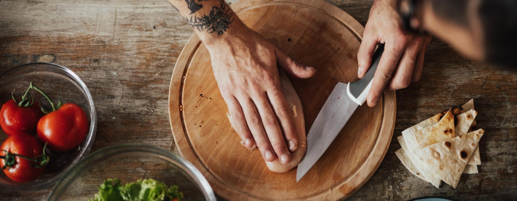 a person cutting chicken