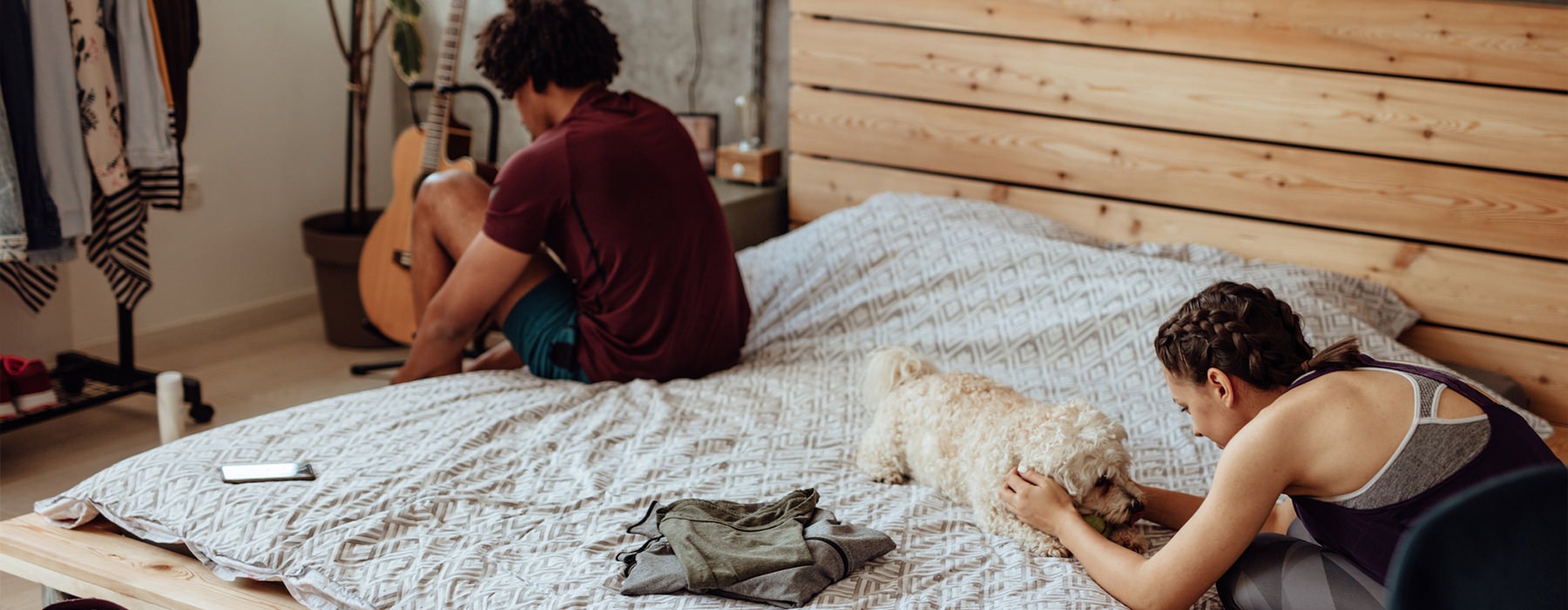 a person sitting on a bed with a dog